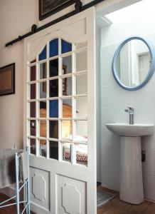 a bathroom with a door with a sink and a mirror at Chambres d'hôtes Villa l'espérance in Étretat
