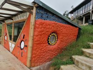 a building that is painted red and blue at Cabaña MonteNube EcoConcientizate in Silvania
