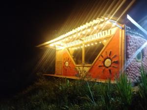 a train car with lights on a wall at night at Cabaña MonteNube EcoConcientizate in Silvania