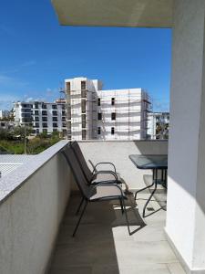 a balcony with a chair and a table on a building at Iris Apartments Ksamil in Ksamil