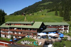 a building with a green roof in a mountain at IFA Alpenhof Wildental Hotel Kleinwalsertal Adults only in Mittelberg