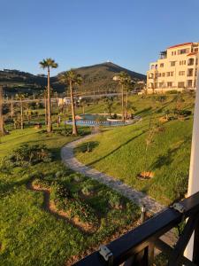 Blick auf einen Park mit Palmen und einem Zug in der Unterkunft Lilacs Garden Cabo in Mʼdik