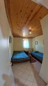 a bedroom with two beds and a wooden ceiling at Peak heaven in Feneos