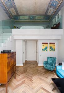 a living room with a blue couch and a ceiling at Galleria Vik Milano in Milan