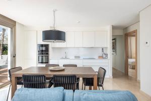 a kitchen and dining room with a wooden table and chairs at Las Terrazas de Abama Suites in Guía de Isora