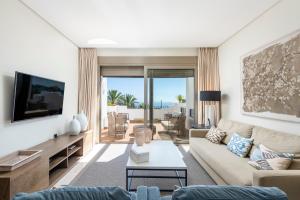 a living room with a couch and a tv at Las Terrazas de Abama Suites in Guía de Isora