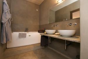 two sinks in a bathroom with a tub and a mirror at Hotel San Giovanni Resort in Saluzzo