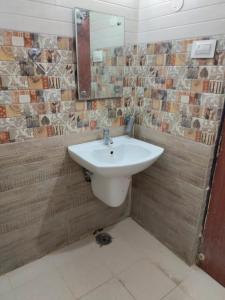 uma casa de banho com um lavatório e um espelho em Mahathi Residency 