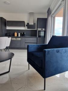 uma sala de estar com um sofá azul e uma cozinha em Deluxe Apartment Mila em Nin