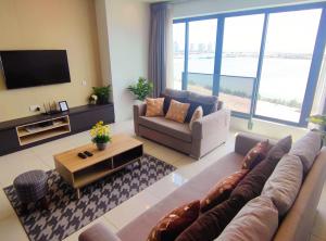 sala de estar con sofá y TV en Seaview Duplex Sunrise Gurney 2BR 一级棒海景の楼中楼, en George Town