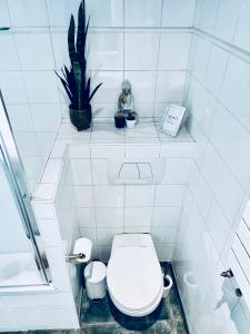 uma casa de banho branca com um WC e uma planta em Luxury Flat in Le Marais - Central Paris em Paris