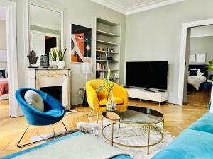uma sala de estar com um sofá e uma televisão em Luxury Flat in Le Marais - Central Paris em Paris