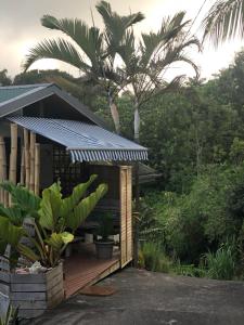 ein Haus mit einem Sonnendach auf einer Holzterrasse in der Unterkunft Bungalow: La Favéla Chic/The Chic Favela - Trois-Rivières in Trois-Rivières