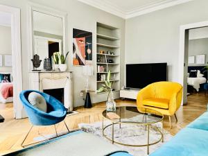 uma sala de estar com duas cadeiras e uma televisão em Luxury Flat in Le Marais - Central Paris em Paris