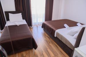 1 dormitorio con 2 camas y suelo de madera en MS Hotel en Dobra Voda