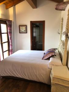 Apartamentos Rurales Quintana de LLanes في يانس: غرفة نوم بسرير ابيض كبير ونافذة