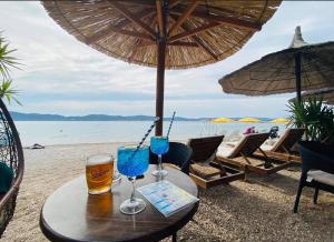 a table with two glasses of beer on a beach at Apartment David in Biograd na Moru