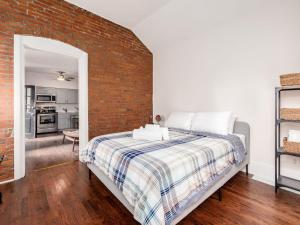 a bedroom with a brick wall and a bed at Cute German Village Lilhauscity Parkpetsok in Columbus