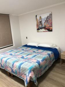ein Schlafzimmer mit einem Bett und einem Wandgemälde in der Unterkunft ALTOS DE HUAYQUIQUE in Iquique