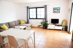 a living room with a couch and a tv at SURF DREAM House in Corralejo