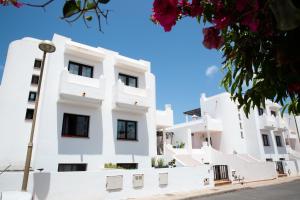 a white building with black windows at SURF DREAM House in Corralejo