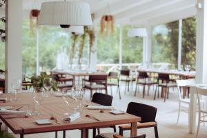 restauracja z drewnianymi stołami, krzesłami i oknami w obiekcie La Pampa Relais & Spa w mieście Melizzano
