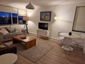 a living room with a couch and a table at Newly renovated apartment! in London