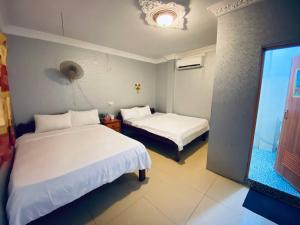 a hotel room with two beds and a television at Elephant Guesthouse in Koh Rong Island