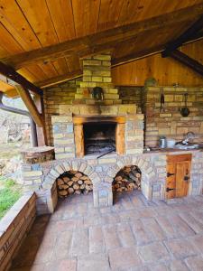 un horno de piedra al aire libre con techo de madera en Fruška house en Bešenovački Prnjavor