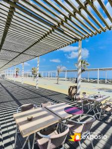 patio ze stołami i krzesłami na plaży w obiekcie LA CABANE DE LA MER w mieście Leucate