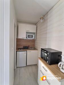 małą kuchnię z kuchenką i kuchenką mikrofalową w obiekcie LA CABANE DE LA MER w mieście Leucate +15 zdjęć