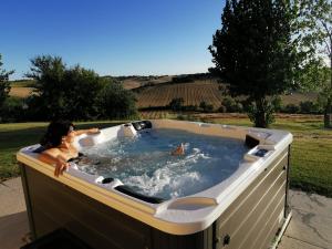 a woman in a jacuzzi tub in a field at Il Campetto Country House in Senigallia