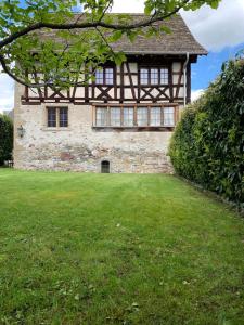a large stone building with a large yard in front of it at Luxury stay in 250 year old wine farm house and gardens in Rüschlikon