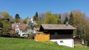 a house on a hill next to a green field at Ruhig gelegenes Ferienhaus in Simmelsdorf