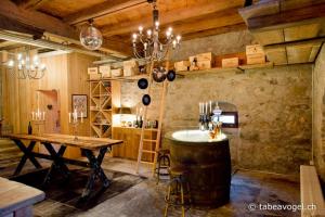 uma grande sala com uma mesa e um barril de vinho em Luxury stay in 250 year old wine farm house and gardens em Rüschlikon