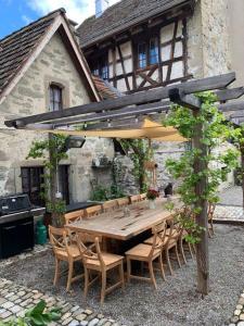 a wooden table and chairs under an umbrella at Luxury stay in 250 year old wine farm house and gardens in Rüschlikon