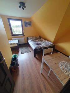 a room with two beds and a table in it at LONDYNEK in Poronin