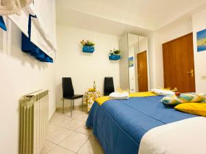 una camera da letto con un letto e delle sedie blu e gialli di Casa Mare Naxos Flat - Home Holiday a Giardini Naxos