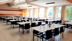 - une salle à manger avec des tables, des chaises et des fenêtres dans l'établissement Residencia Diego Martinez, à Palencia