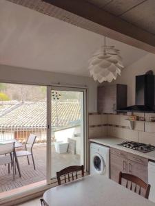 a kitchen with a table and a kitchen with a patio at Maison de village avec terrasse in Luc-en-Diois