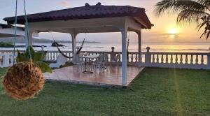a gazebo with a table and chairs in front of the ocean at Casa de Campo, frente a la playa Skybluebyguanche in Colón