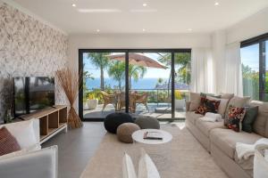a living room with a couch and a tv at Villa Hibiscus by An Island Apart in Calheta