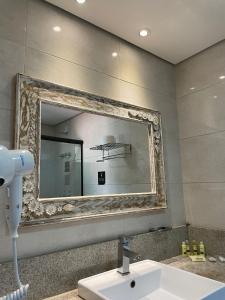 a bathroom with a mirror and a sink at Pousada Verde Villas in Brumadinho