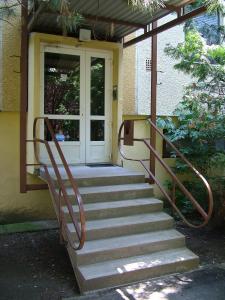 un conjunto de escaleras que conducen a una puerta principal en Jókai Apartman Szarvas, en Szarvas