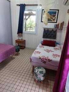 1 dormitorio con cama y ventana en LES GÎTES DU DOMAINE DE PETITE-ANSE en Bouillante