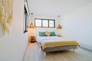 a bedroom with a bed and two windows at Maison bohème au bord de l'eau in Sète