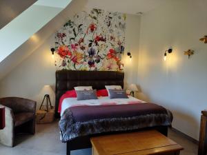 Le Clos des Pommiers في Tracy-sur-Mer: غرفة نوم مع سرير جداري به زهور على الحائط