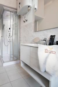a white bathroom with a shower and a sink at Mr. Brown - Camillo in Rome