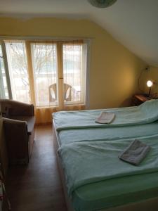 um quarto com uma cama, uma cadeira e janelas em Vikendica Vidikovac na Zavojskom jezeru em Pirot