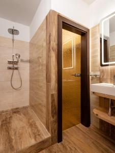 Wellness Hotel Ondrášův dvůr في بيلا: حمام مع دش ومغسلة